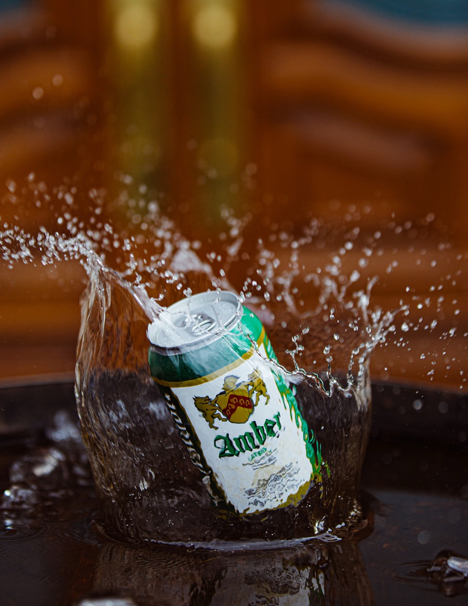 Altstadt beer can product photograph with splash on a dark background