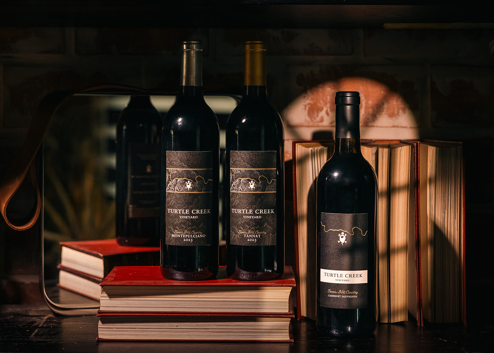 Wine bottle lineup photographed on a dark background for a Hill Country winery